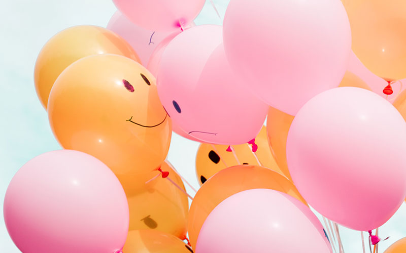 Picture of a bunch of balloons with some smiling and some frowning
