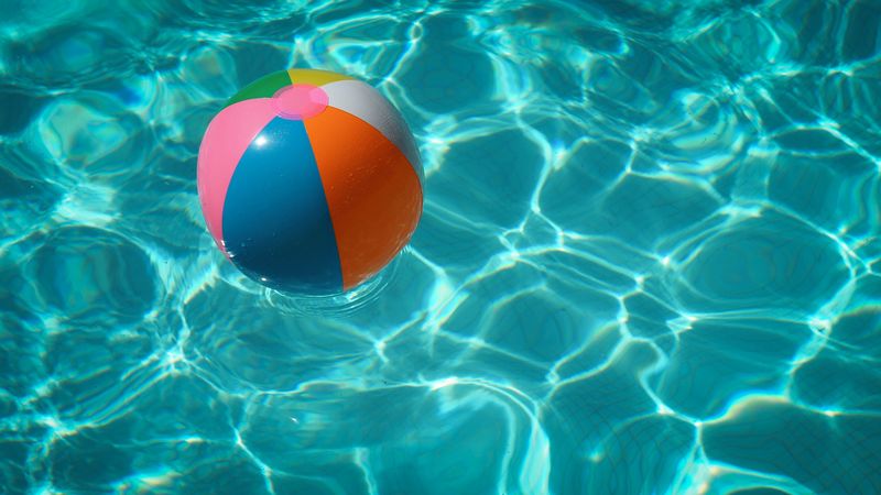 A beach ball floating in a clear swimming pool