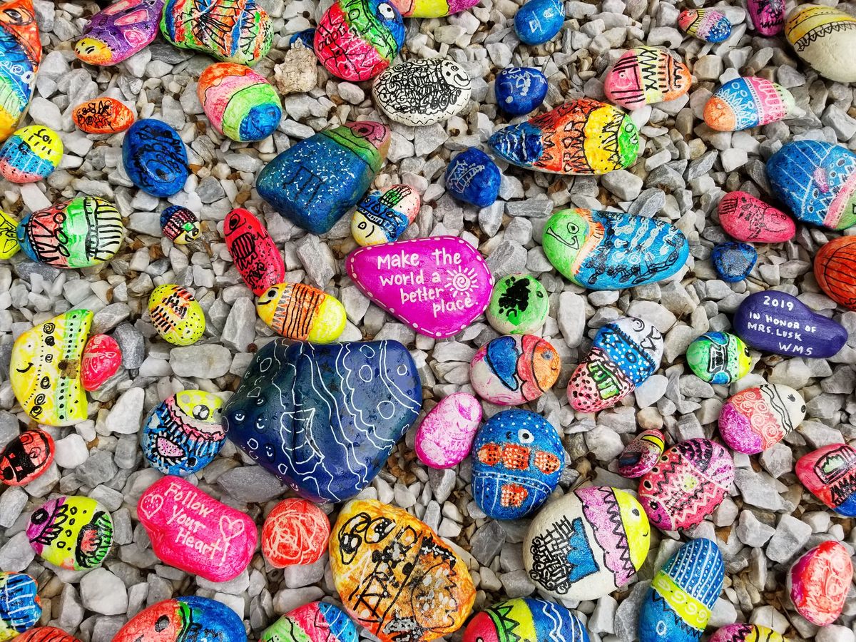 Colourful pebbles on the beach with writing on them