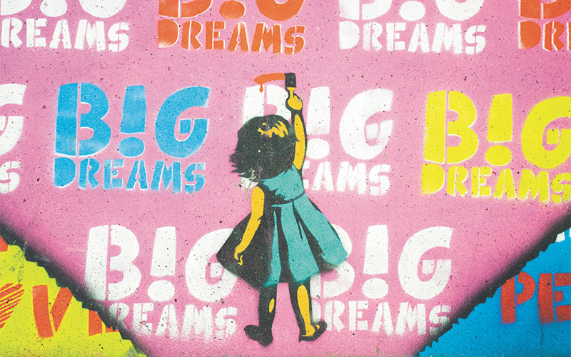 Picture of girl painting over a poster background.