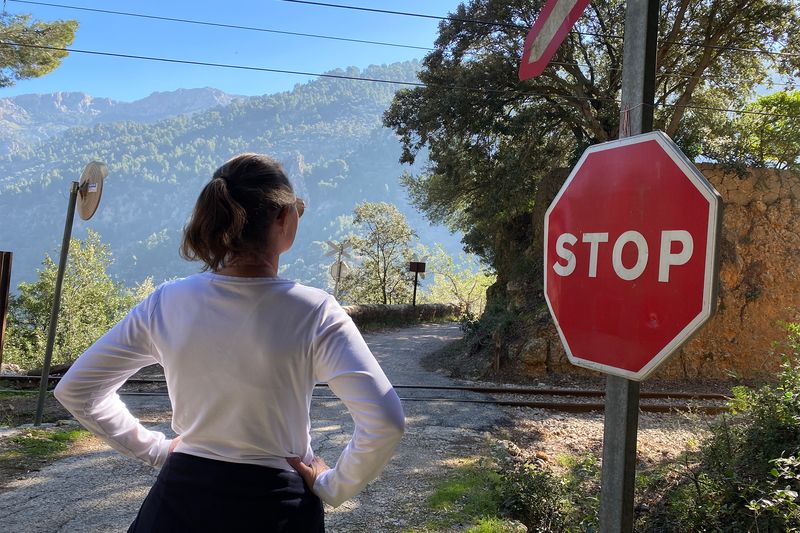 Picture of Tiffany Barnard waiting for a train at a stop sign.